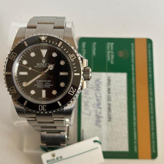 Rolex watch with a card and tag on a light gray background